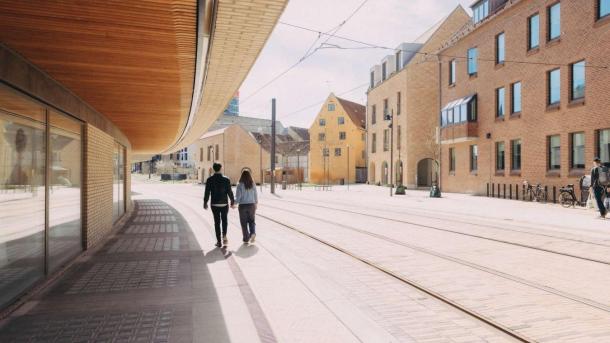 Et par går hånd i hånd langs med letbanens tracé i Odense bymidte.