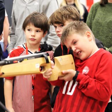 Dreng skyder til mål mens to andre drenge står og kigger på til Sportslørdag 2023