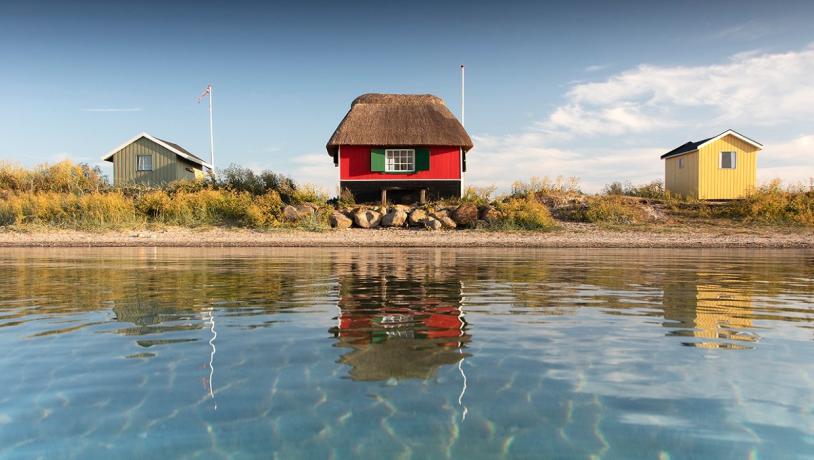 Tre badehuse ved Eriks Hale ved Marstal. Blå himmel og blåt vand.