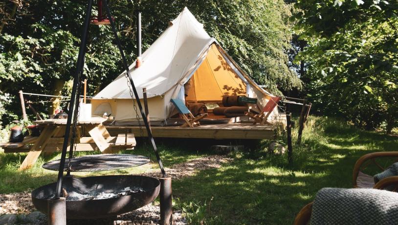 Glamping telt står midt i grønne og hyggelige omgivelser.