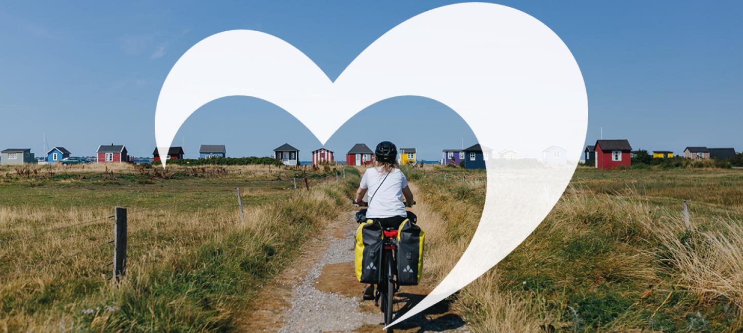 Cyklist på vej til Vester Strand ved Ærøskøbing. Over billedet er grafisk rendering af Destination Fyns hjerte-bomærke.