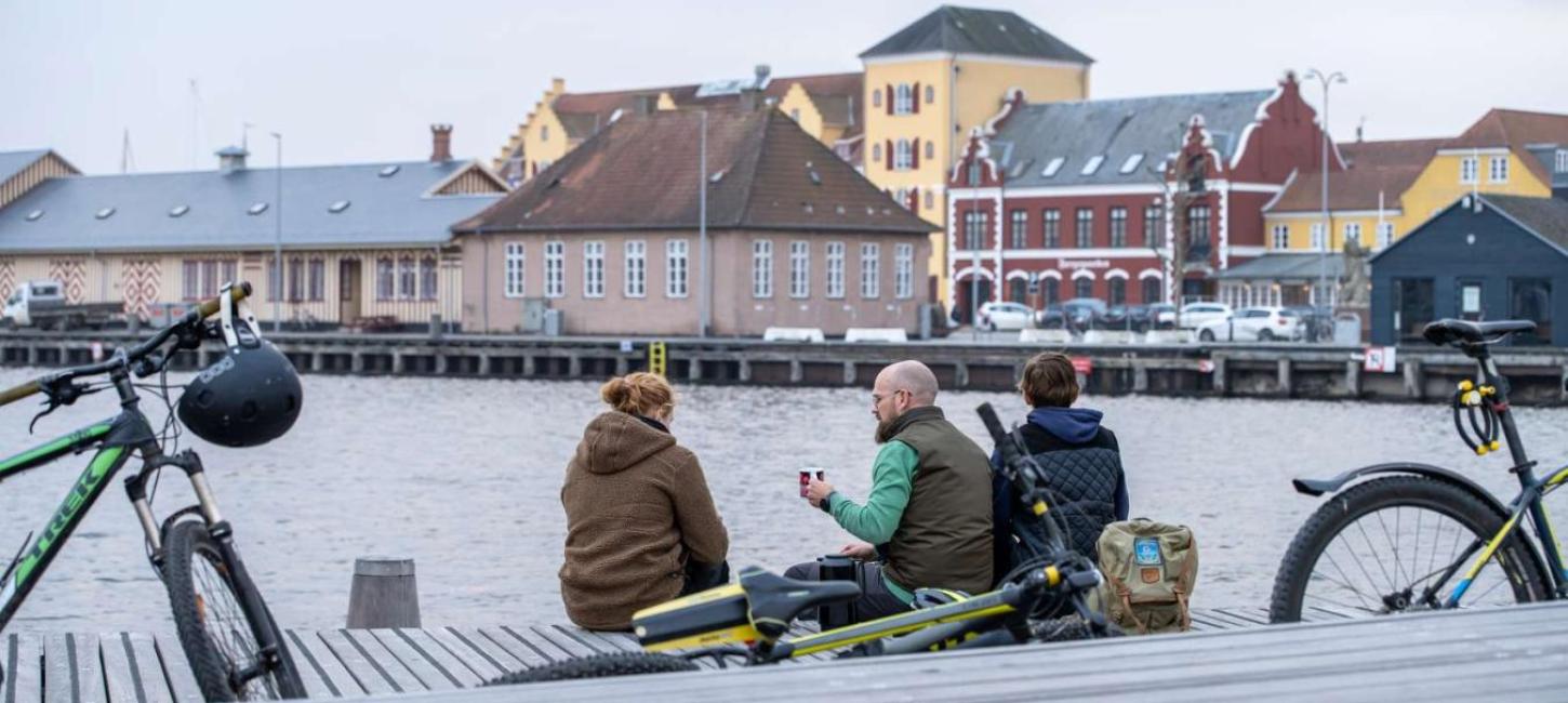 Tre cyklister holder pause ved Svendborg Havn. 
