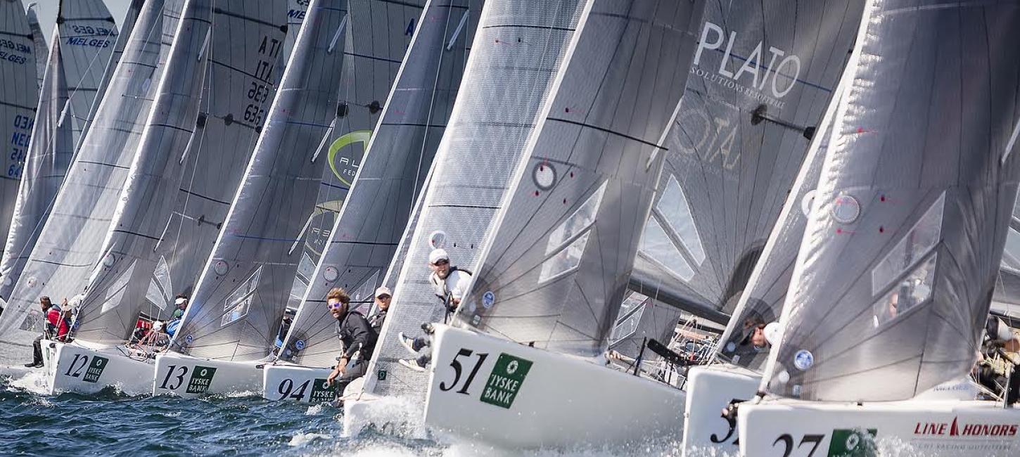 En masse hvide Melges-både med sejlere på ræd og række på havet