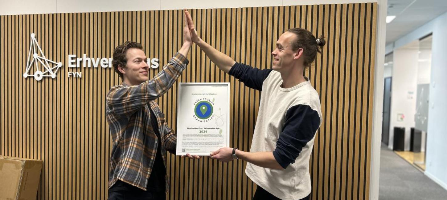 Destination Fyns Mark Hauge Østergaard og Erhvervshus Fyns Philip Eldridge giver highfive på, at GTO-certificeringen igen er i hus.