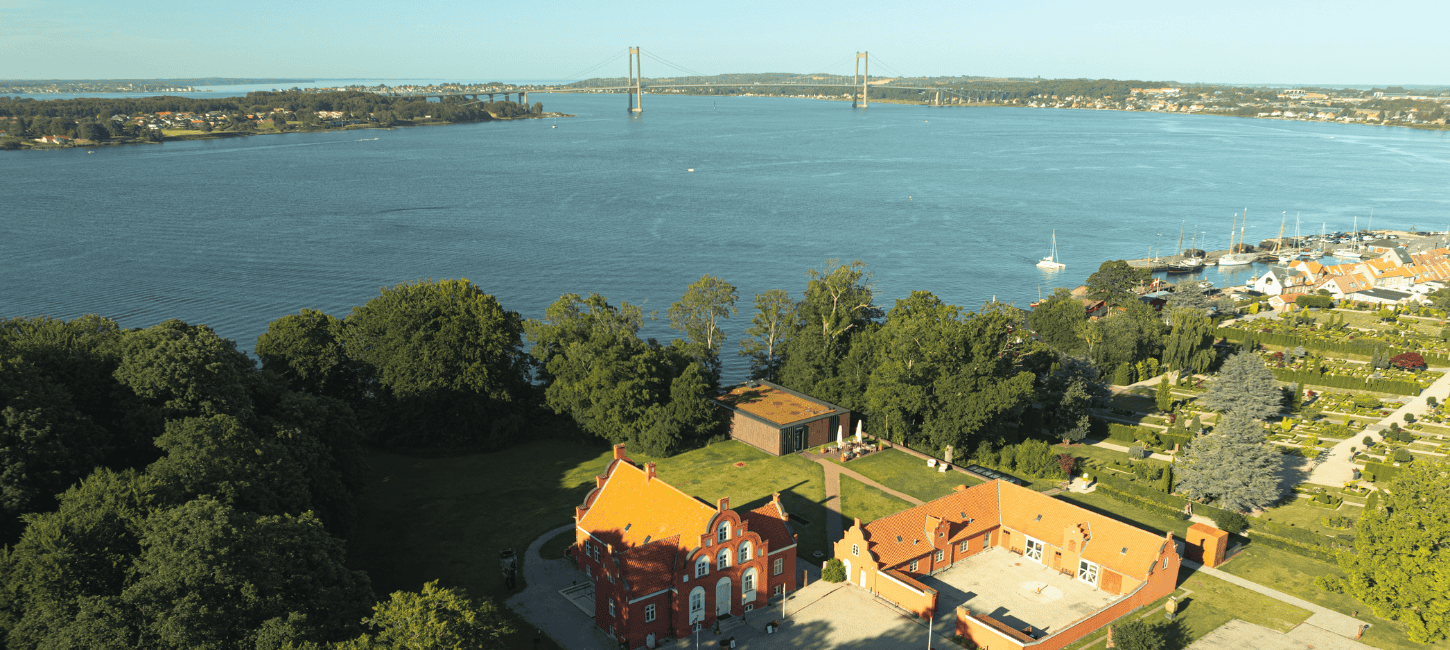 Et luftbillede af lillebælt, den nye lillebæltsbro, keramikmuseet CLAY og den gamle havn i Middelfart