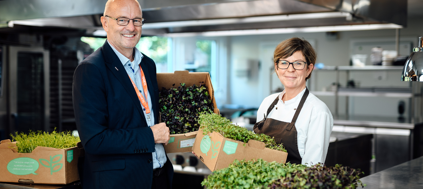 Hoteldirektør og køkkenchef med kasser af spirende grønt