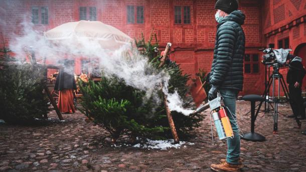 Foran rødt bindingsværkshus oser et juletræ efter det er blevet slukket med en brandslukker  