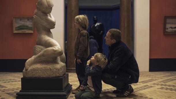 Far og to små drenge kigger på en skulptur på Faaborg Museum