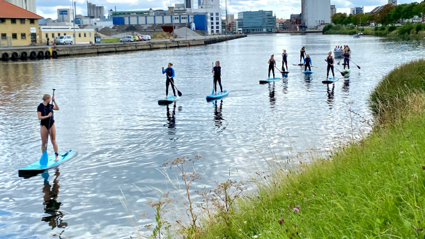 Odense kanal med ni mennesker på stand up paddle board