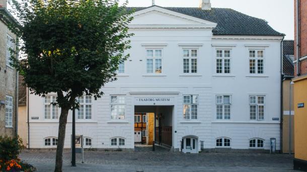 Hvid bygning med træ foran