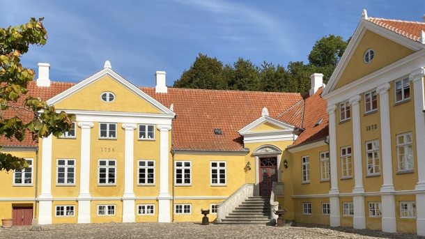 Broløkke Herregård med sol på den gule facade