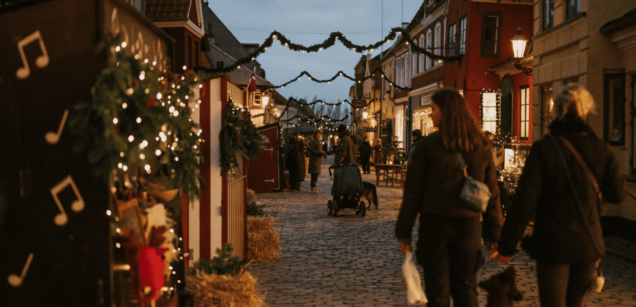 Stemningsfuldt julemarked i Ærøskøbing på Fyn med julepyntede huse, lysguirlander og besøgende, der nyder juletiden. En hyggelig decemberaften fyldt med julehygge og den særlige stemning, der kendetegner jul på Fyn og øerne.