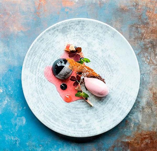 Gourmetdessert smukt anrettet set oppefra på rustikt bord.