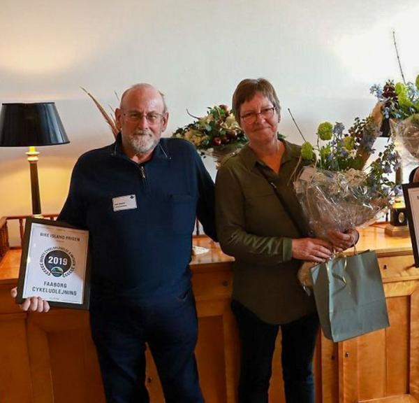 Tre glade modtagere af Bike Island-prisen på Fyn 2019 står med deres overrakte blomster og diplom.