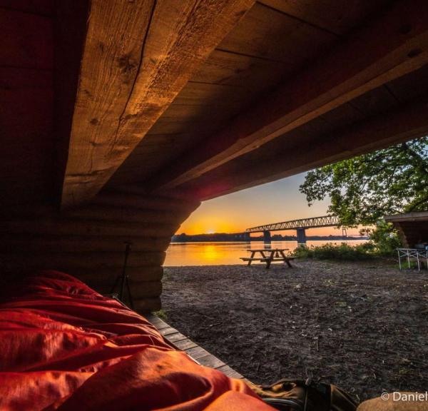 Overnatning i shelter på strand med udsigt over bro