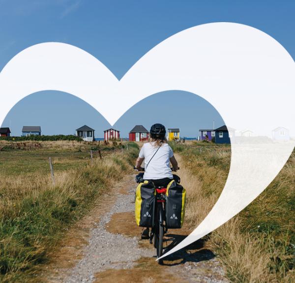 Cyklist på vej til Vester Strand ved Ærøskøbing. Over billedet er grafisk rendering af Destination Fyns hjerte-bomærke.