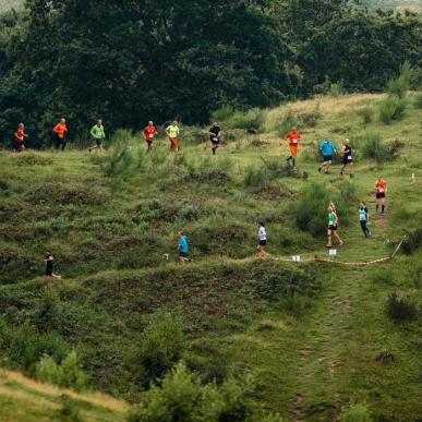 En stor gruppe mennesker i forskelligfarvet løbetøj løber i en lang række ved Svanninge Bakker. 
