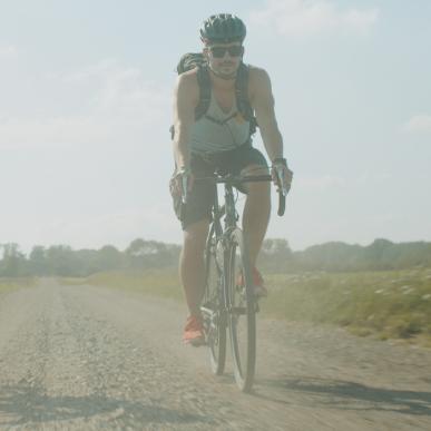 Far og søn på gravel bikes på støvet grusvej.