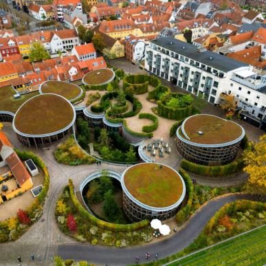 Dronefoto af H. C. Andersens hus, der består af en klynge af runde bygninger med mos på taget