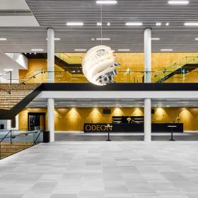 Stor, tom sal i Odeon, hvor man kan se, etagen overover også. Der er trapper i venstre og højre side af salen og en stor, rund lampe hænger ned i midten af billedet og oplyser salen.
