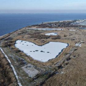 Set fra luften kan man observere havet med en masse kyst, hvor der er en sø, der er formet som et hjerte