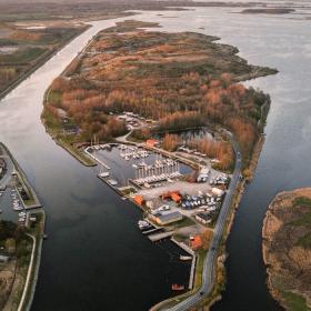 Lille ø i varme efterårsfarver set foroven, fotograferet med drone. 