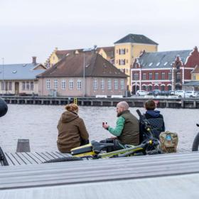 Tre cyklister holder pause ved Svendborg Havn. 