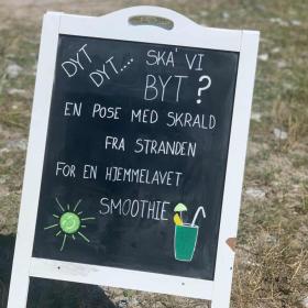 Skilt med teksten: "Dyt dyt ska' vi byt? En pose skrald fra stranden for en hjemmelavet smoothie"